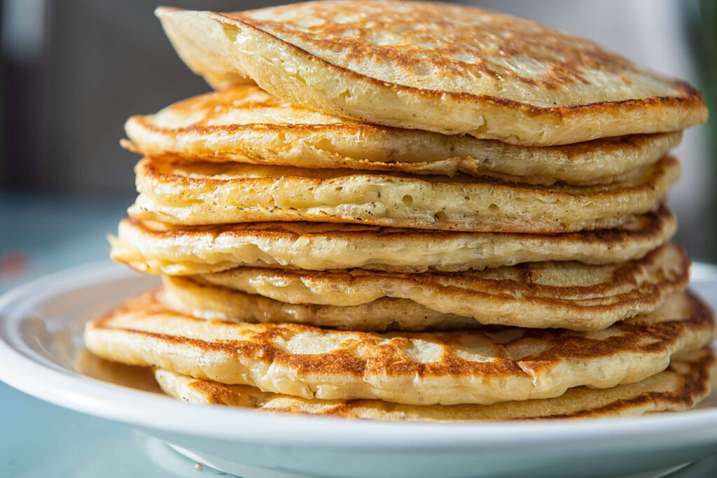 Macro closeup side view of stack of buttermilk pancakes on plate